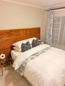 a bed with two pillows on it in a bedroom at Kilimanjaro in Alberton