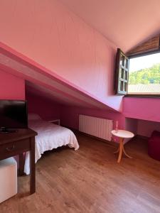a bedroom with pink walls and a bed and a window at Posadaochohermanas in Las Fraguas