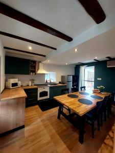 a large kitchen with a wooden table and a tableasteryasteryasteryasteryasteryastery at House Belej - Lola in Belej