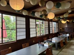 a restaurant with tables and chairs and paper lanterns at Guest house Mitaki in Hiroshima