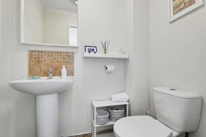 a white bathroom with a toilet and a sink at Stylish 3 Bedroom with Balcony and Amazing View in Dollar +14 photos