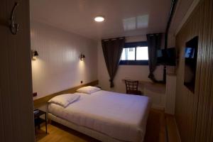 a bedroom with a bed and a bathroom with a tub at Hotel Arcantis Le Voltaire in Rennes