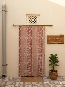 a shower curtain in a room with a plant at The Heritage Eco Stay in Bikaner