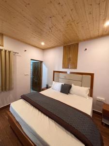 a bedroom with a large bed with a wooden ceiling at Forest Breeze Homestay in Kanatal +23 photos