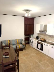 a kitchen and living room with a couch and a table at Le Statuine Dimore Diffuse in Barletta