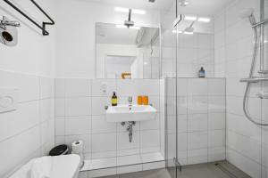 a white bathroom with a sink and a toilet at Arbio I Cube Studios & Apartments St Pauli in Hamburg +94 photos