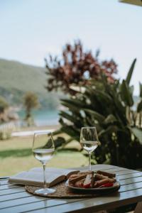 a table with two wine glasses and a plate of food at Aiora Suites in Syvota