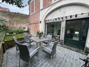a patio with a table and chairs and a building at Maison hypocentre de Bethune in Béthune