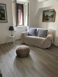a living room with a couch and a ottoman at Appartamento La Fontina in Marciana Marina
