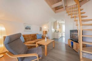 a living room with a couch and a staircase at Ferienanlage Seeblick Aquamarin in Koserow