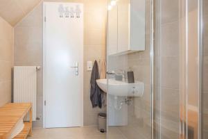 a small bathroom with a sink and a shower at Ferienanlage Seeblick Aquamarin in Koserow +24 photos