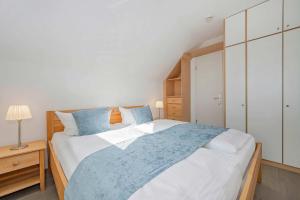 a bedroom with a large bed with blue pillows at Ferienanlage Seeblick Aquamarin in Koserow