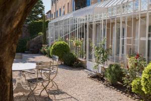 a glass greenhouse with a table and some plants at La Madone in Apt