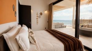 a bedroom with a bed and a view of the ocean at The Cliff Residences in Plomari +94 photos