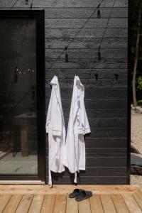 a pair of white coats hanging on a door at Armoni Ski & Spa in Cantley +60 photos