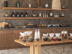 a table with food and bottles of wine on it at Ovea Paros in Naousa +32 photos
