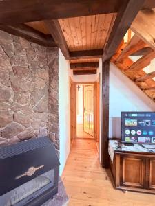 a room with a fireplace and a stone wall at Zov Dičine in Savinac