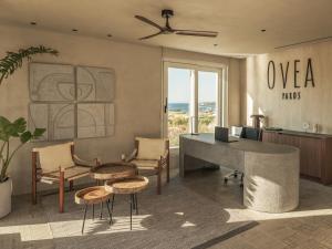 an office with a desk and a table and chairs at Ovea Paros in Naousa