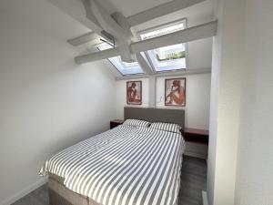a bedroom with a bed and two skylights at Brauhaus Suite 16 in Sebnitz +23 photos