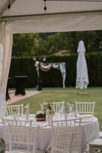 a table with white chairs and a table with glasses at Zov Dičine in Savinac +27 photos
