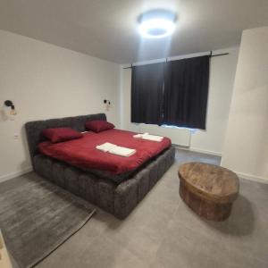 a bedroom with a large bed with a red comforter at House for Tomorrowland in Rijweg
