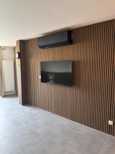 a living room with a television on a wall at House for Tomorrowland in Rijweg