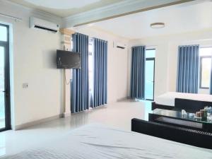 a bedroom with a bed and a tv and windows at PHƯƠNG LƯU Hotel in Văn Lâm