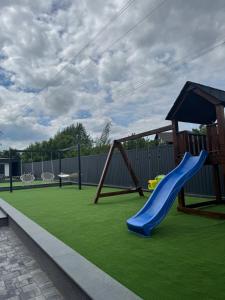 a playground with a blue slide and a swing at Gravity Resort & Spa in Solotvyno