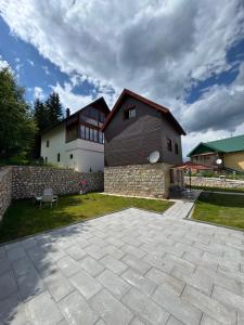 a house with a stone patio in front of it at Modern in center in Žabljak