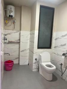 a bathroom with a white toilet and a window at Hotel Paradise in Neihdawn