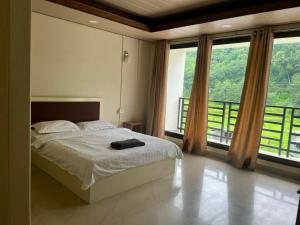a bedroom with a bed and a large window at Hotel Paradise in Neihdawn +1 photo