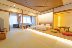 a bedroom with a bed and a living room at Hanasuishou in Fuefuki