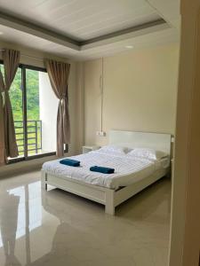 a bedroom with a white bed in front of a window at Hotel Paradise in Neihdawn