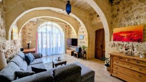 a living room with a couch and a table at Razzett Pepprina Poppy Farm in Xagħra