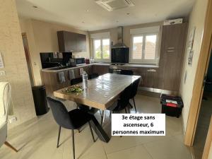 a kitchen with a table and chairs in a room at Appartements centre ville Colmar 4 familles in Colmar