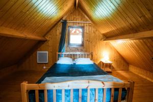 a wooden bedroom with a bed in a attic at Domaine Guillaume Chalet 6p classic in Auquainville +48 photos