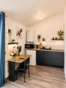 a kitchen with a wooden table and a counter top at Le Studio, proche du puy in Saint-Pierre-Montlimart
