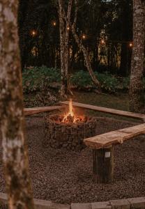 a fire pit in a park with a bench at Hotel Cabanas Glamour in Gramado +91 photos