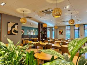 a restaurant with wooden tables and chairs and potted plants at De Vere Horsley Estate in East Horsley