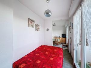 a bedroom with a red blanket on a bed at Charmant Studio Cabine 4 Pers, Balcons, Parking Privé, à 300m de la Plage de Merville-Franceville - FR-1-465-37 in Merville-Franceville-Plage