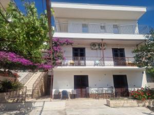 an apartment building with tables and chairs on the balcony at Apartmani Batinović - Baška Voda in Baška Voda +3 photos