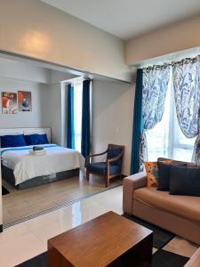 a hotel room with a bed and a couch at C1-7G Executive Studio with pool , 8boulevard Mactan Newtown in Lapu Lapu City +25 photos