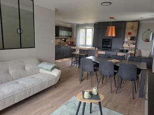 a living room with a couch and a table and chairs at VILLE au VERT in Verdun-sur-Meuse