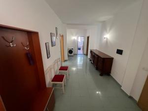 a hallway with two chairs and a dresser in a building at Vila Vollga in Durrës