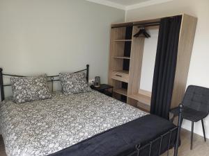 a bedroom with a bed and a chair at VILLE au VERT in Verdun-sur-Meuse