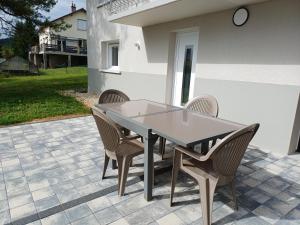 a dining table and chairs on a patio at VILLE au VERT in Verdun-sur-Meuse +11 photos