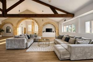a living room with a couch and a table at Les Arches d'Or - Loft 200 m2 avec Rooftop, Jacuzzi et 3 Suites - Centre 5 min - Proche A7-A9 in Orange