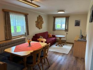 a living room with a table and a couch at Bergbauernhof Haug in Bad Hindelang