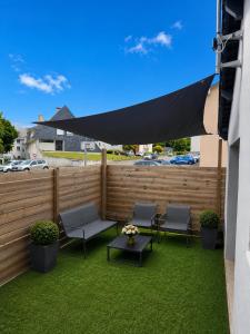 a patio with chairs and a table and a fence at Le Studio, proche du puy in Saint-Pierre-Montlimart