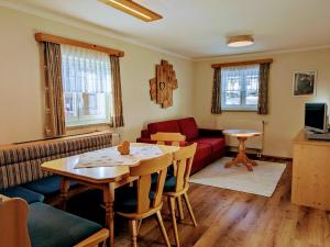 a living room with a red couch and a table at Bergbauernhof Haug in Bad Hindelang